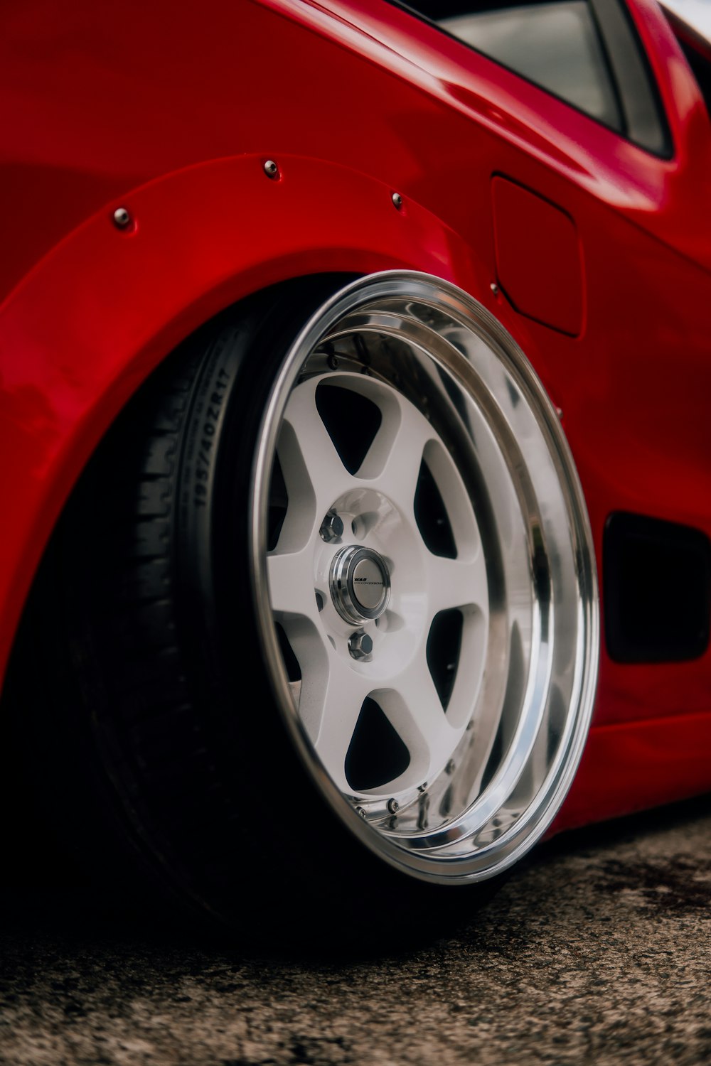 a close up of a red sports car wheel