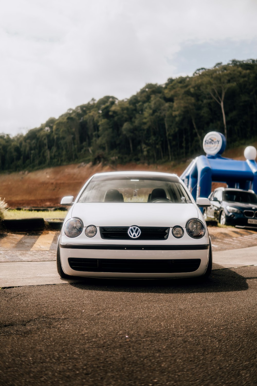 a white car parked in front of a blue structure