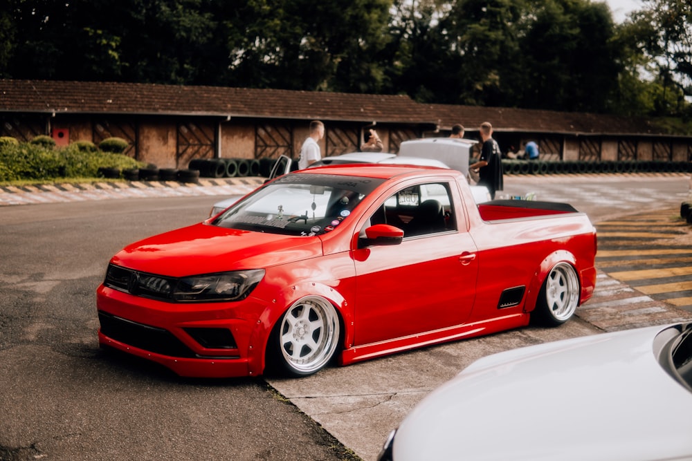 a red pick up truck parked in a parking lot