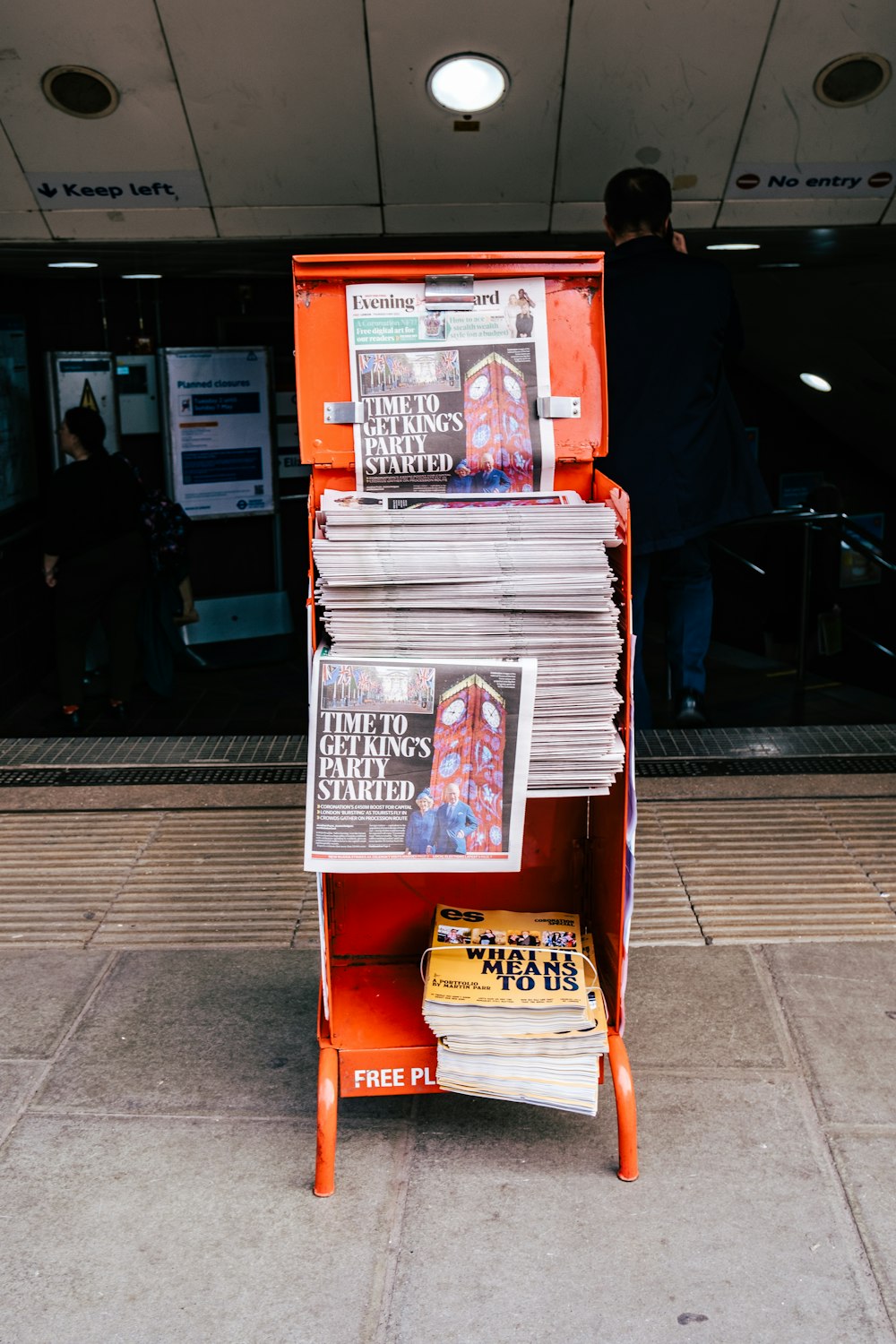 a stack of newspapers sitting on top of a wooden stand
