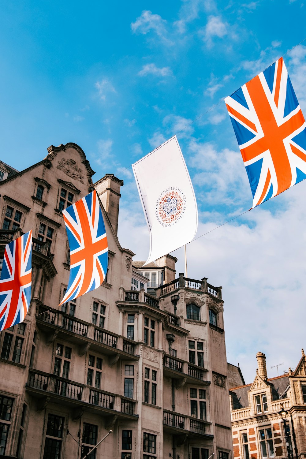 a group of flags flying in front of a building