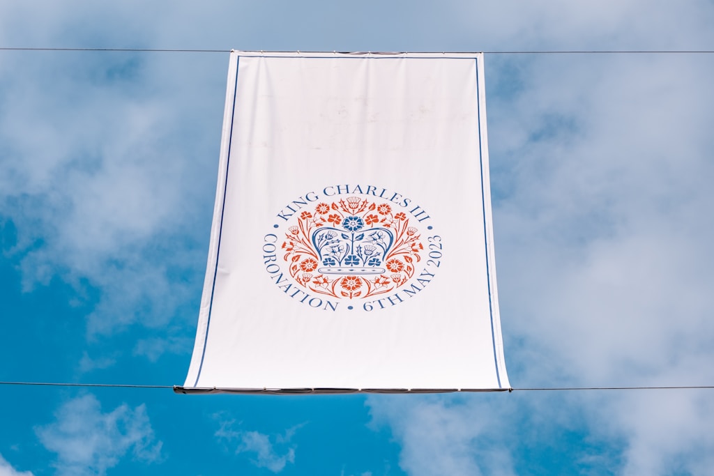 a white banner hanging from a wire with a blue sky in the background