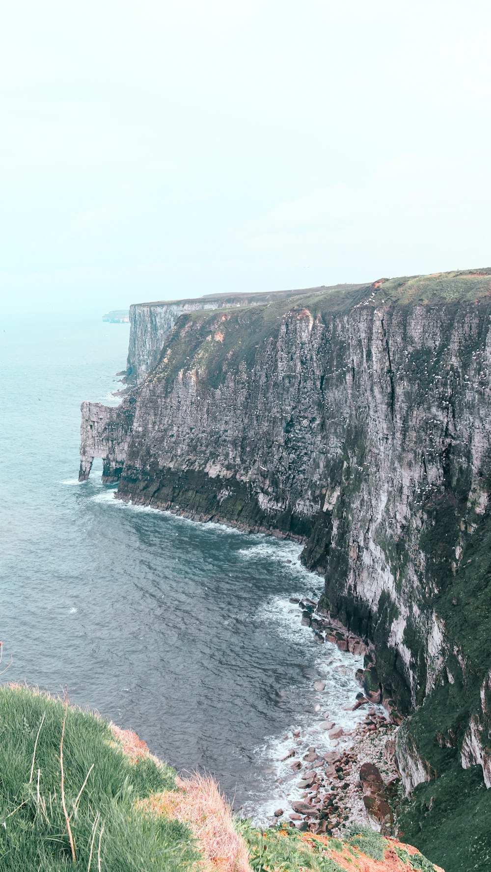 a person standing on a cliff overlooking the ocean