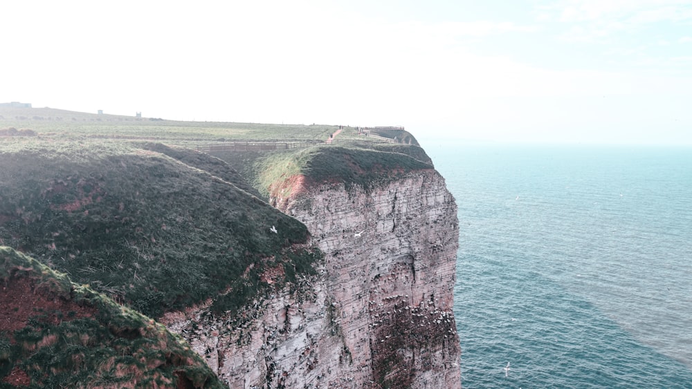 a cliff with a grassy area on top of it