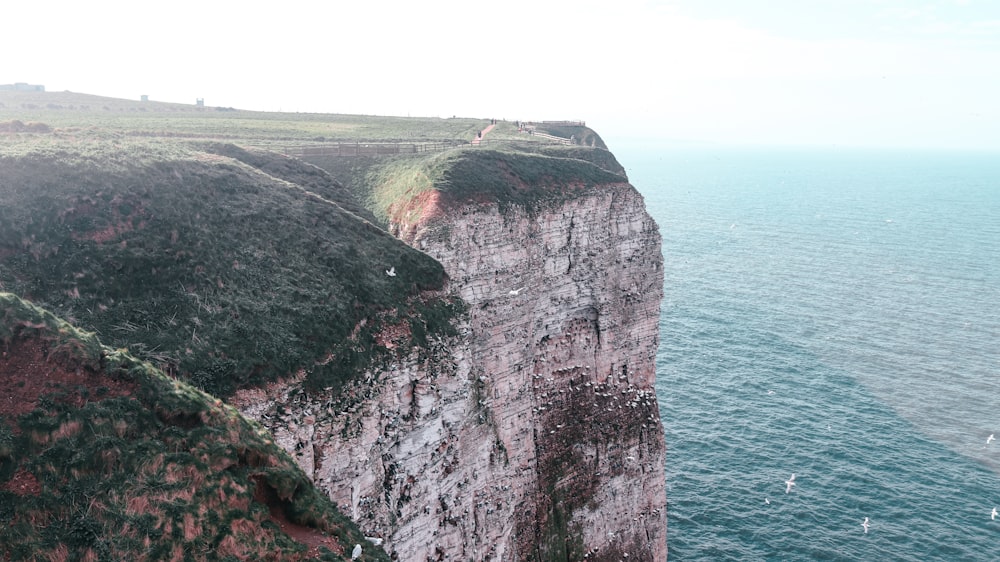 a view of a cliff with a body of water in the background