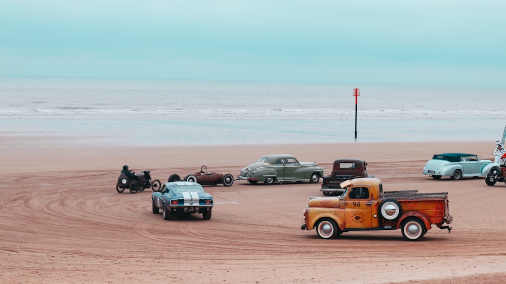 a group of cars parked on top of a sandy beach