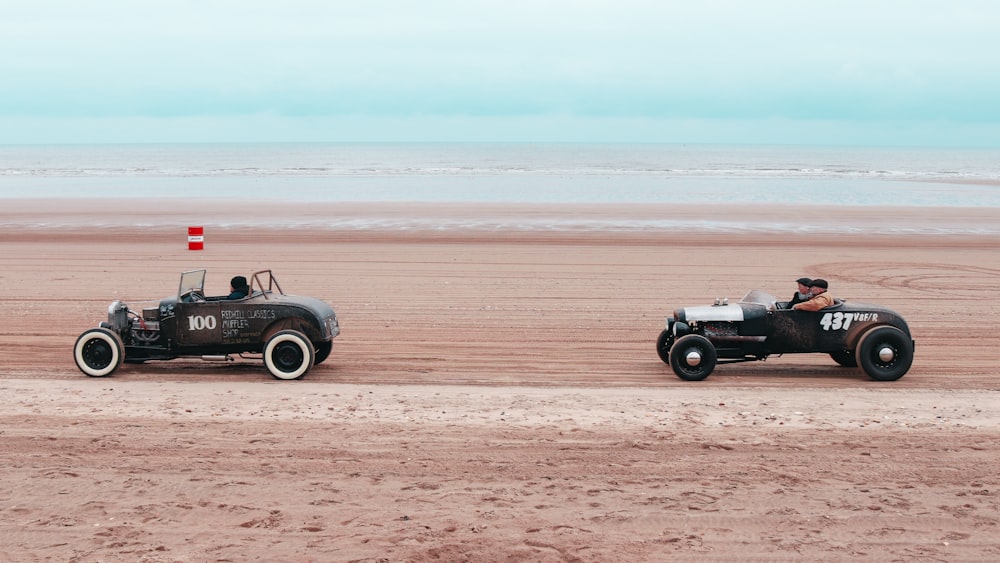 a couple of cars that are sitting in the sand