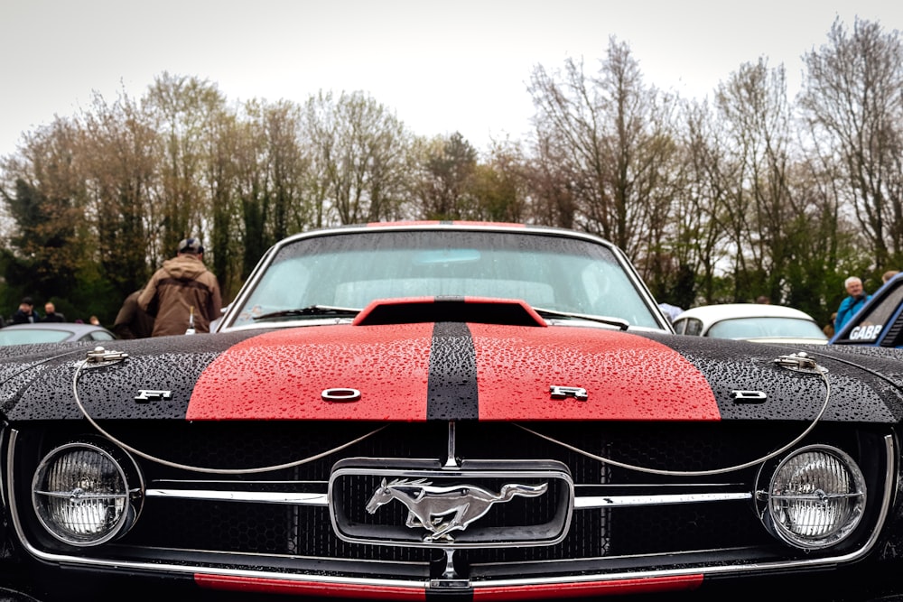 Ein rot-schwarzer Mustang, der auf einem Parkplatz geparkt ist