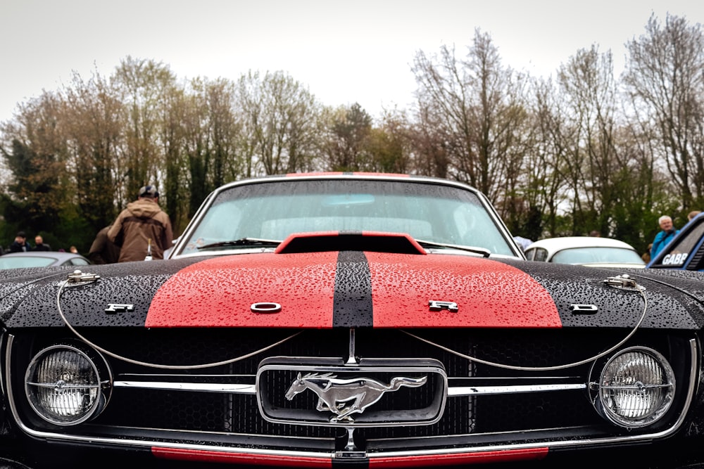 a red and black mustang parked in a parking lot