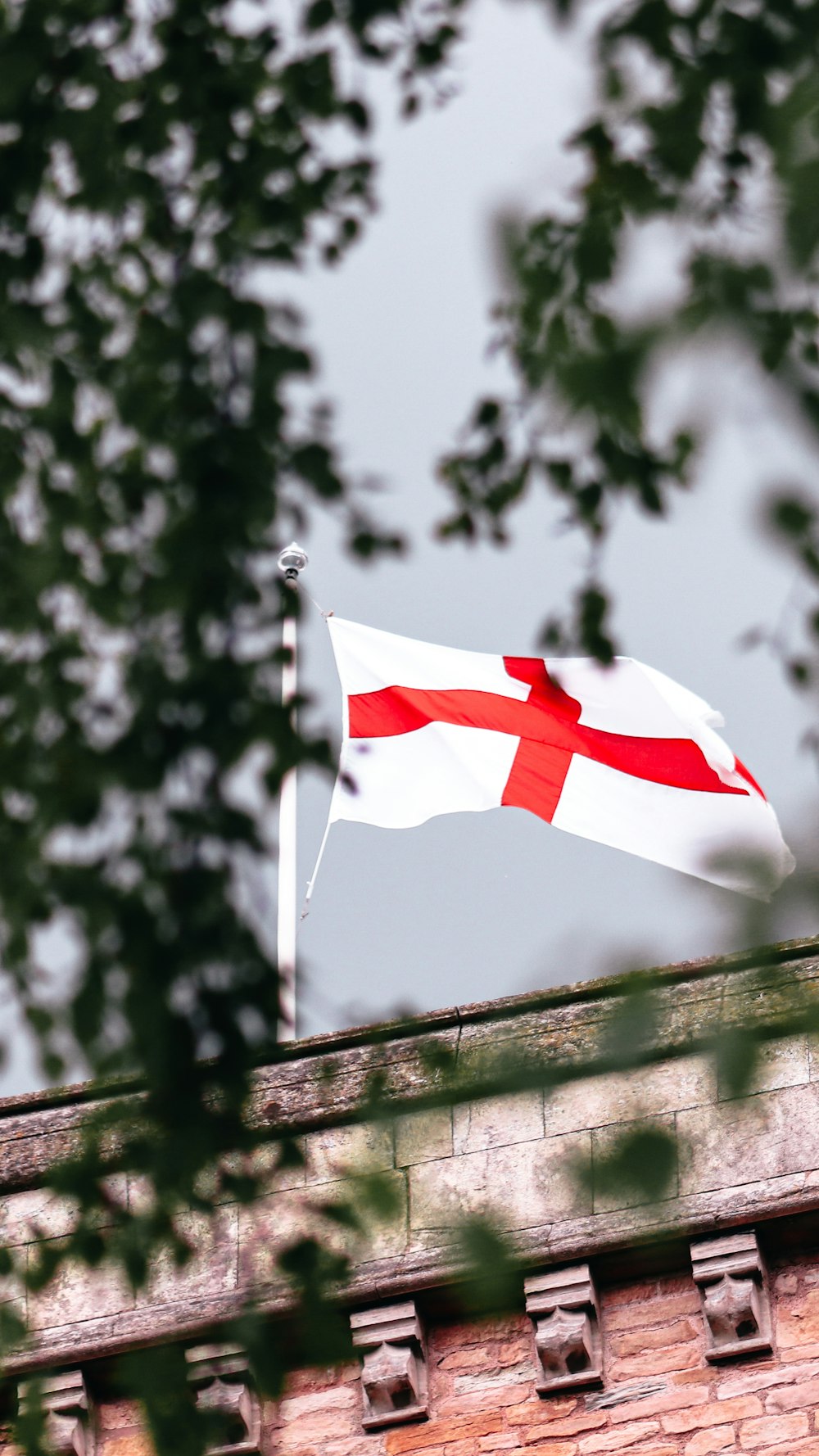 a flag flying on top of a brick building