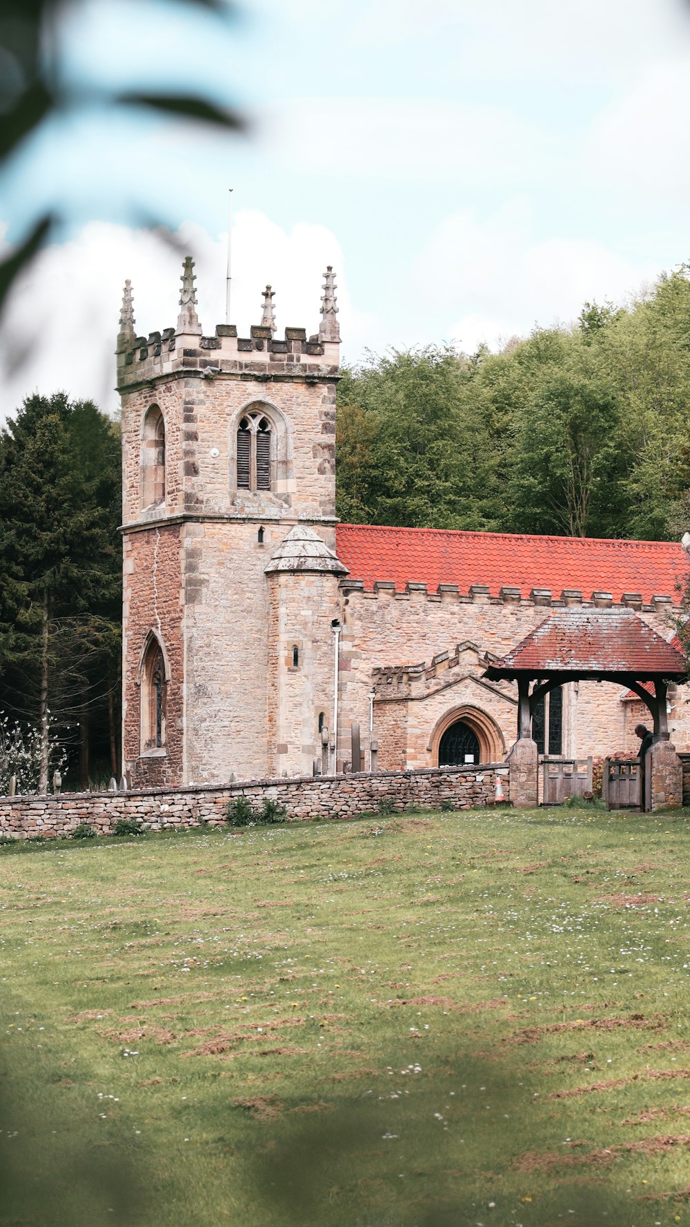 an old building with a red roof in a field