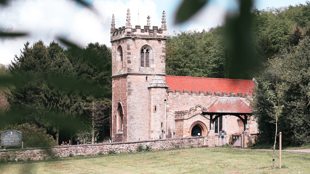 an old church with a red roof surrounded by trees