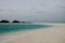a sandy beach with a small island in the distance