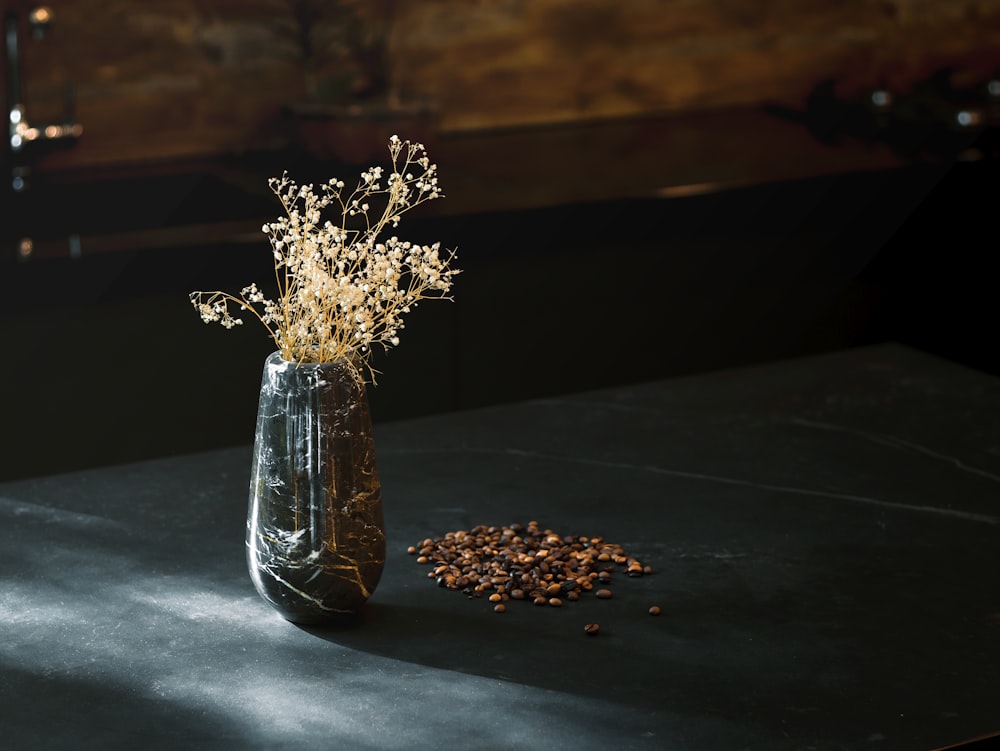 a vase filled with dried flowers on top of a table