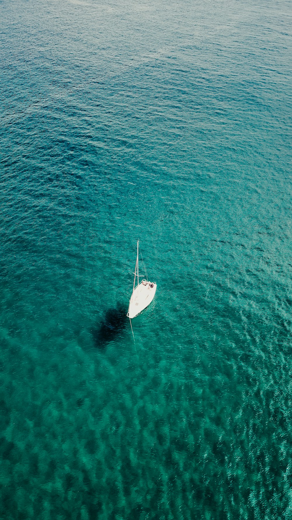 a white boat floating on top of a body of water