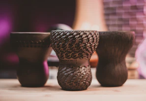 Handcrafted decor pieces arranged minimally on a dark, textured surface.