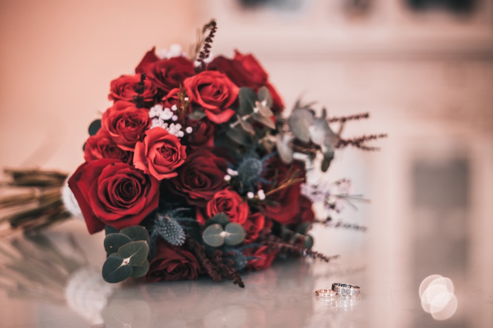 a bouquet of red roses sitting on top of a table
