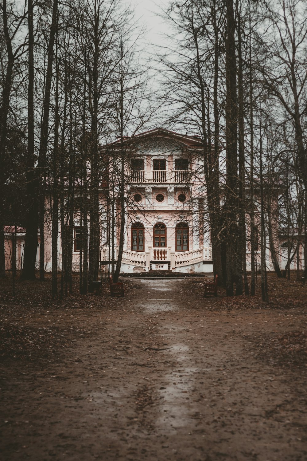 a large house surrounded by trees in the middle of a forest