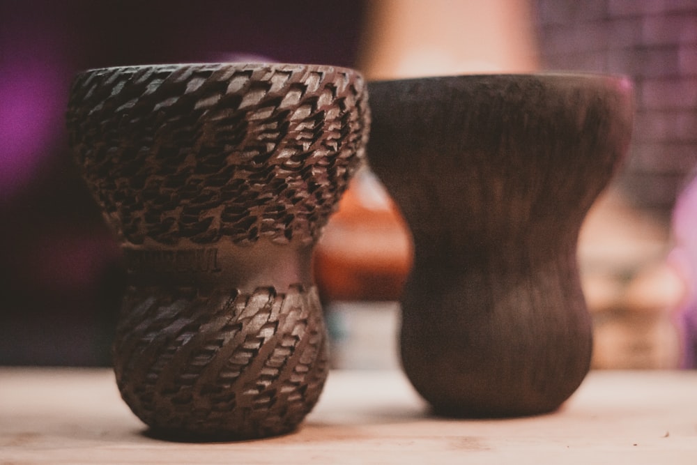 a couple of vases sitting on top of a wooden table