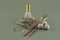 A bottle of herbal oil surrounded by fresh herbs.