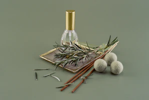 A small amber bottle of herbal oil resting beside green leaves and a wooden spoon.