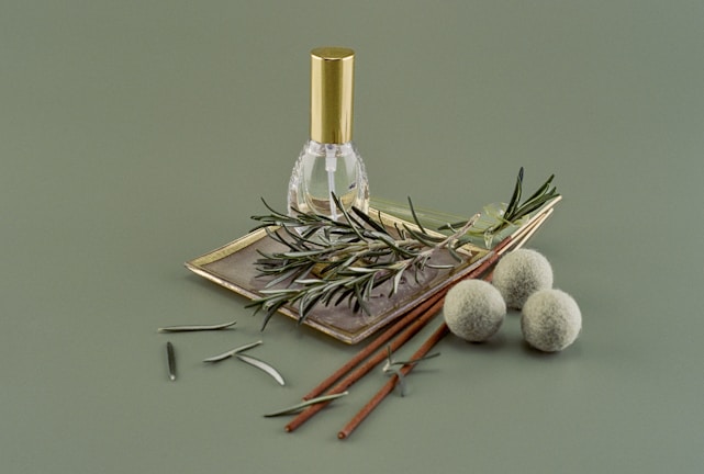 Close-up of a vintage amber glass bottle filled with cold-pressed ayurvedic oil, surrounded by fresh green herbs and golden leaves.