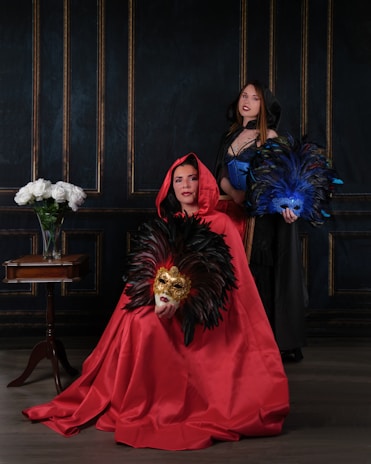 Editorial-style portrait of the duo, showcasing their tailored suits and gold masks with soft champagne accents illuminating their presence.