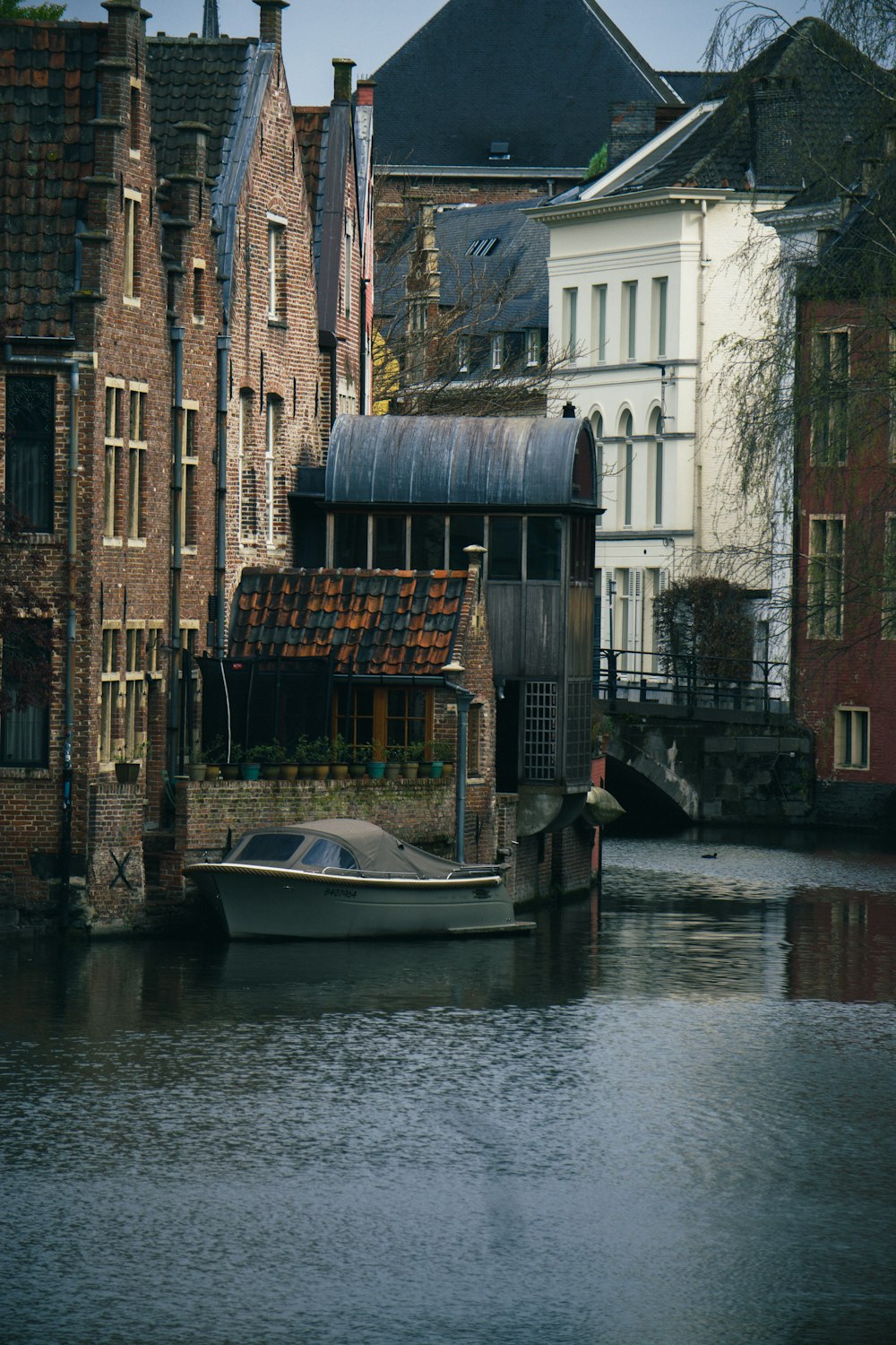 a boat floating on top of a river next to tall buildings