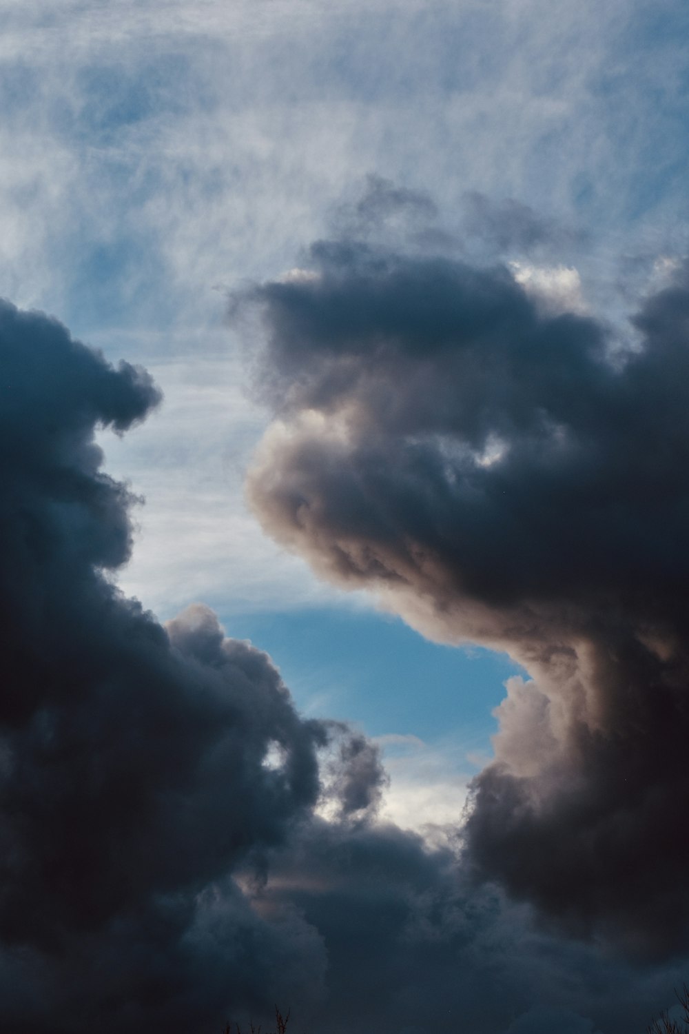 a plane flying through a cloudy blue sky