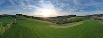 A panoramic view of a lush farmland property at sunset.