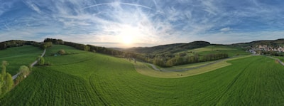 A panoramic view of a lush farmland property at sunset.