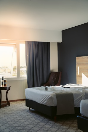 a hotel room with two beds and a chair