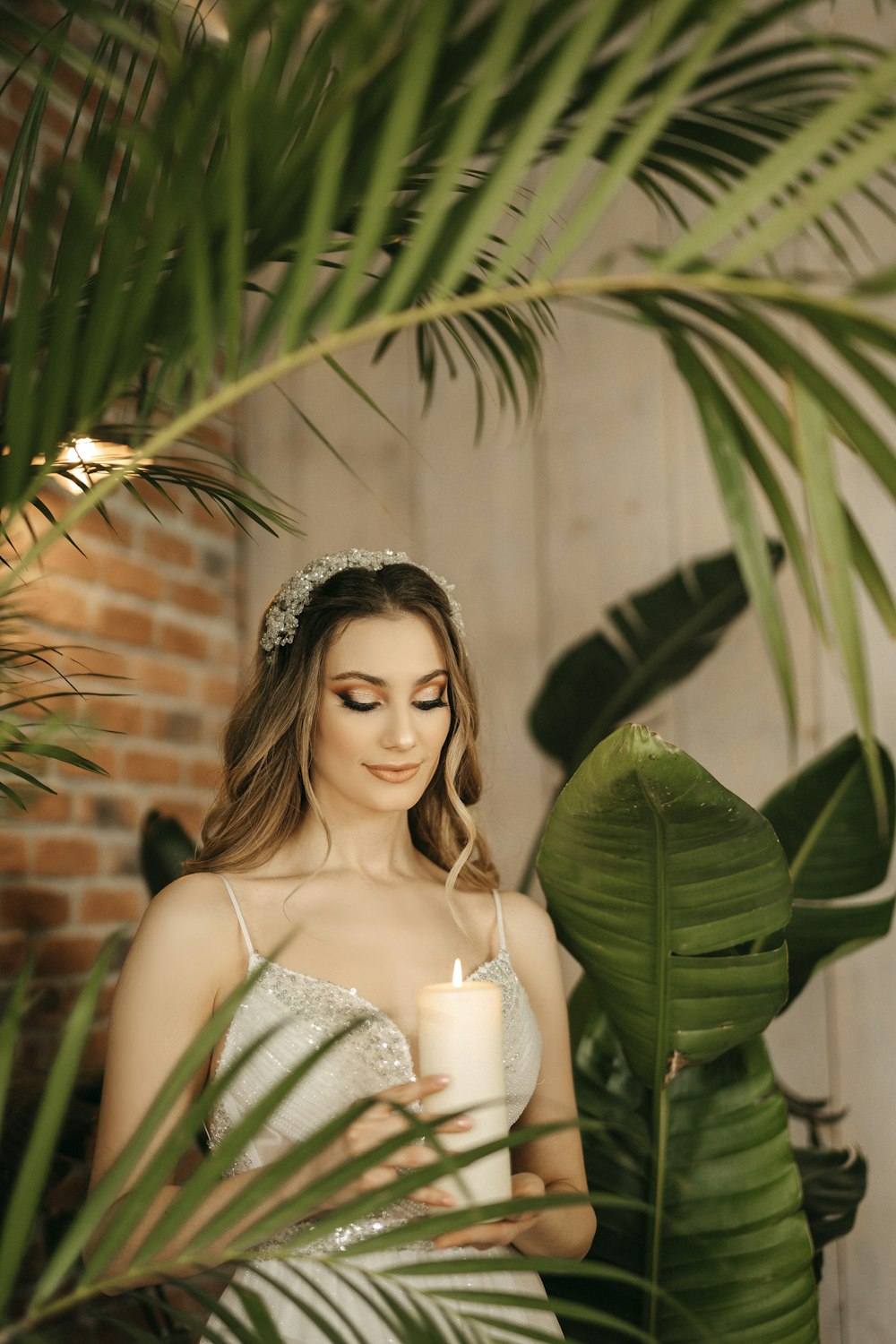 a woman in a wedding dress holding a candle