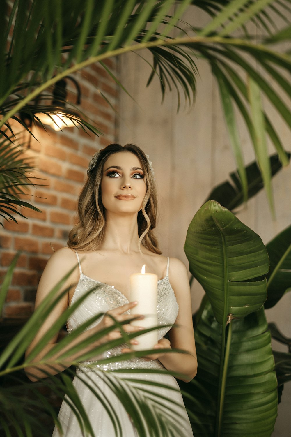 a woman in a wedding dress holding a candle