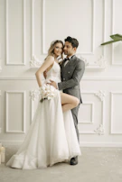 Groom smiling warmly as he waits, framed by soft ivory and blush pink tones.
