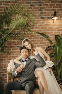 a bride and groom sitting on a chair