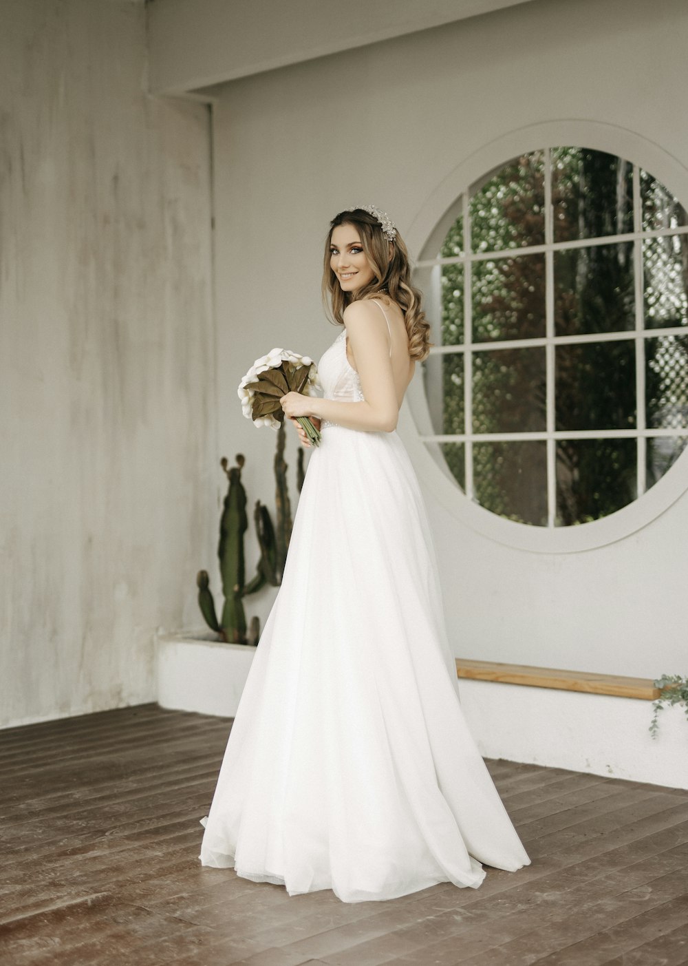 a woman in a white dress holding a bouquet of flowers