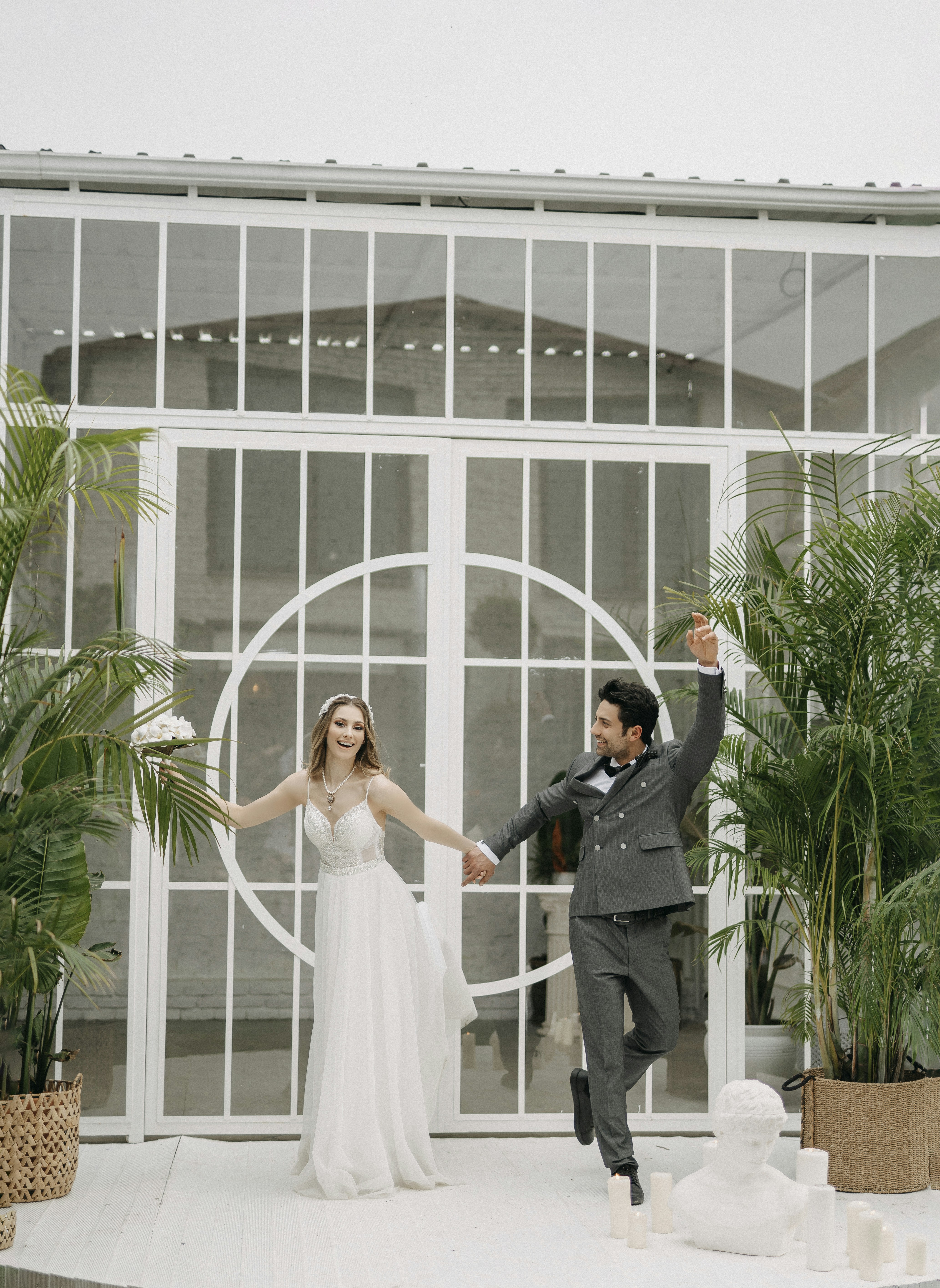 a bride and groom are holding hands in front of a building