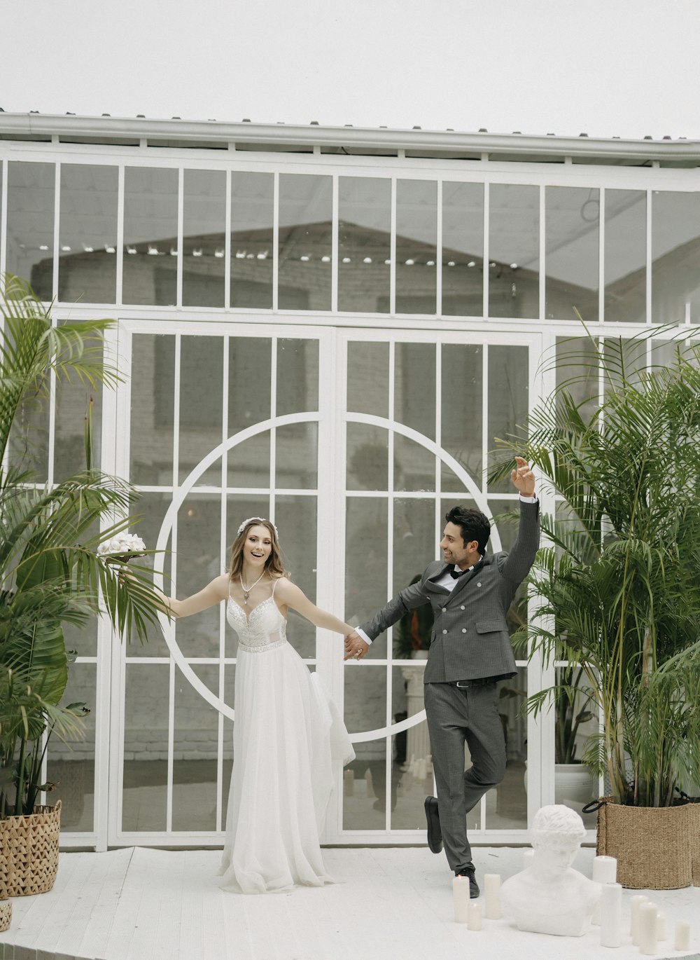 a bride and groom are holding hands in front of a building