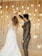 a bride and groom dancing in front of hanging lights
