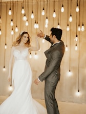 A cinematic shot of a couple dancing under twinkling lights at an elegant outdoor wedding.