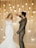 A couple sharing their first dance under twinkling fairy lights, radiating joy and love.