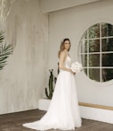 a woman in a white dress holding a bouquet of flowers