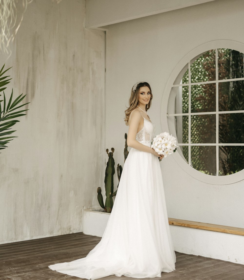 a woman in a white dress holding a bouquet of flowers