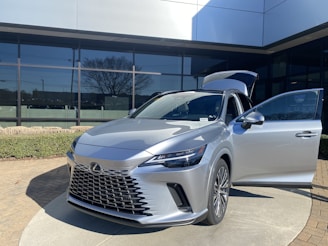 Elegant silver Lexus parked in front of a luxury hotel