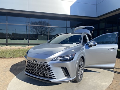Elegant silver Lexus parked in front of a luxury hotel