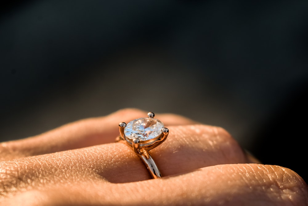 a close up of a person's hand holding a ring