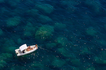 Guests relaxing on the sun deck of a luxury inflatable boat with clear blue sea around