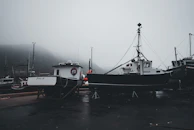 Early morning mist over the ocean horizon with fishing boats anchored.