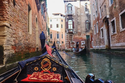 a gondola in a narrow canal with buildings in the background